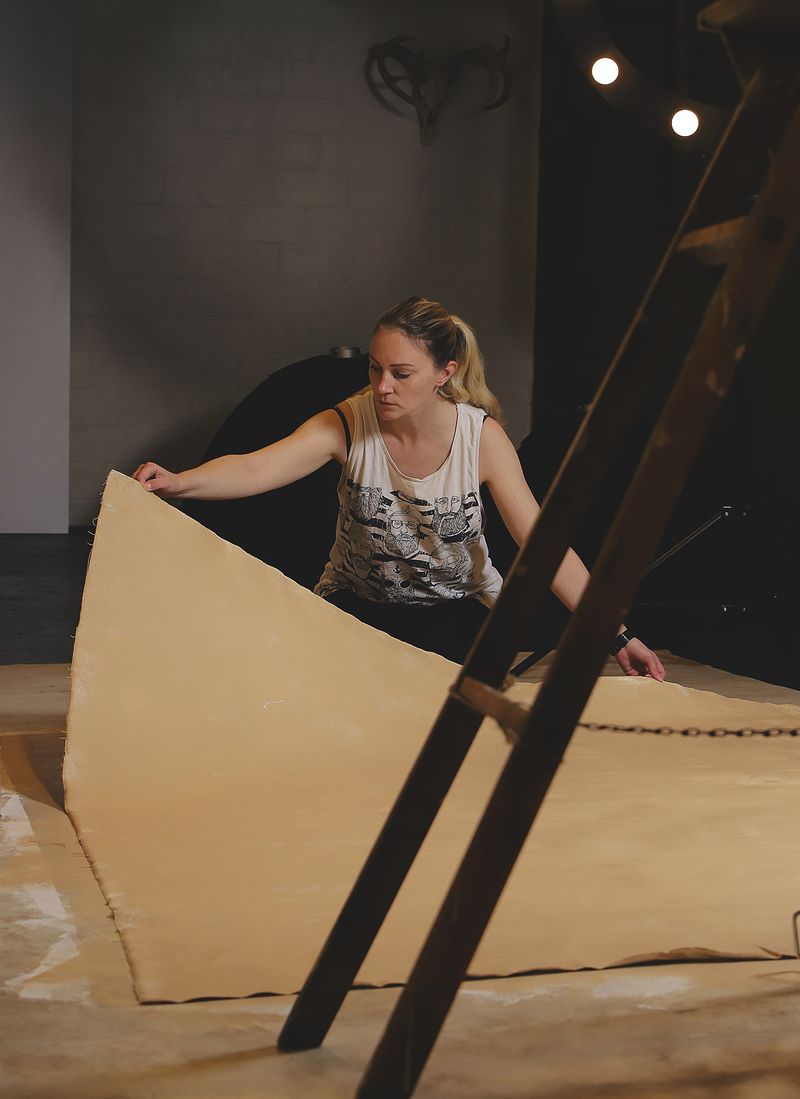 Nadja Mikkilä käsittelemässä maalattua kangasta studiossa